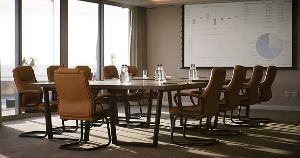 Empty office, screen and chairs in business for meeting, conference or workshop space. Interior, vacant and furniture at boardroom table for finance presentation, data analysis or corporate workplace